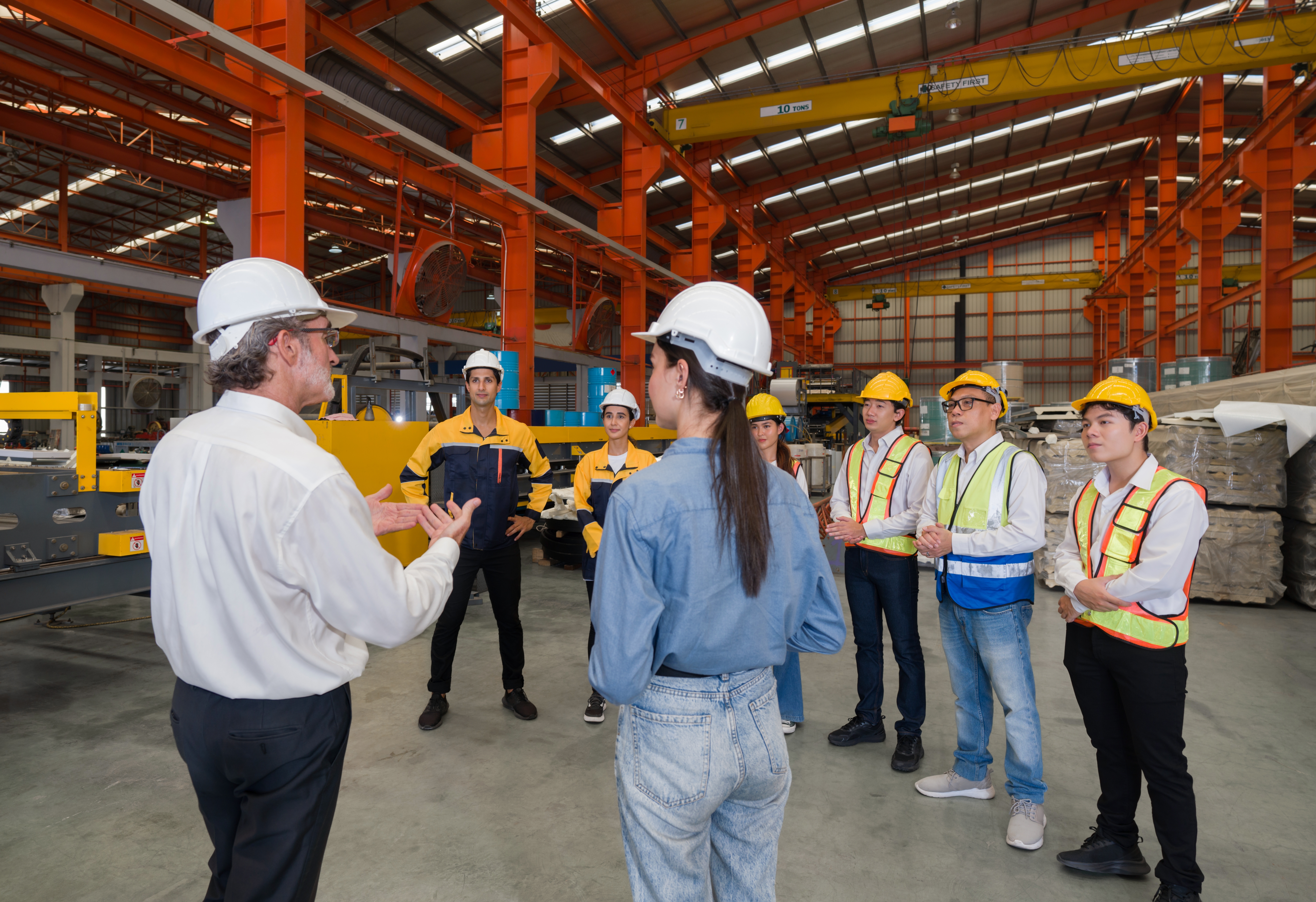 Business owner addressing a team of workers in a factory